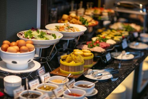 a buffet with plates of food and bowls of food at Salute Premium Hotel & Spa in Hanoi