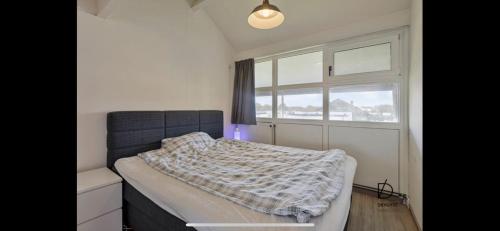 a bedroom with a bed and a window at Duinengolf in Middelkerke