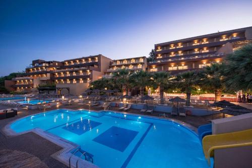 um hotel com piscina em frente a um edifício em Blue Bay Resort Hotel em Agia Pelagia