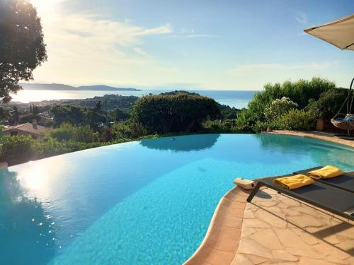 a swimming pool with a view of the ocean at 4-Star Private Villa with Heated Pool and Panoramic Sea View at Gulf de Saint Tropez in Cavalaire-sur-Mer