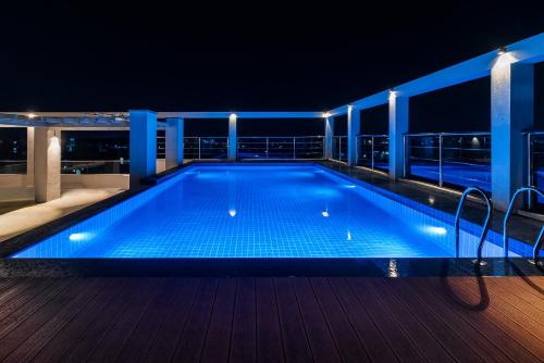 a swimming pool on the deck of a cruise ship at night at Hotel Turmeric in Erode