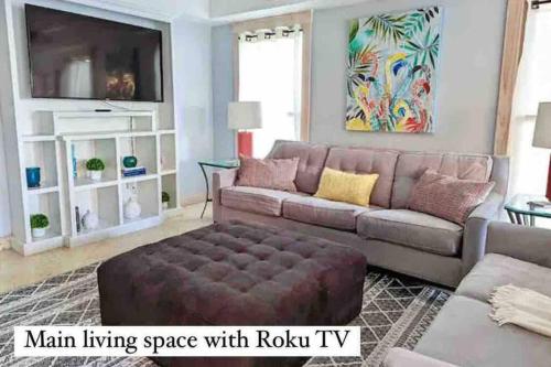ein Wohnzimmer mit Sofa und Fernseher in der Unterkunft Be A Nomad - Oceanviews Bottom and Steps to the Beach in Jacksonville Beach