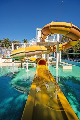 a water slide in a swimming pool with water at Turtle Beach Resort in Gold Coast