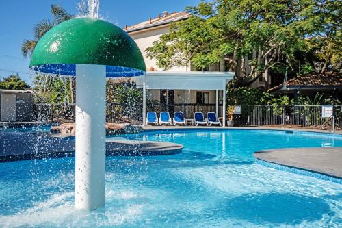 a fountain in the middle of a swimming pool at Turtle Beach Resort in Gold Coast