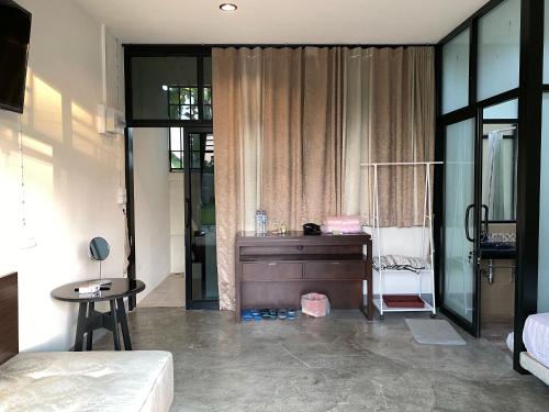 a bedroom with a desk and a bed and a table at Chiangmai Courtyard Residence บ้านสวนสวย บ้านถวาย in Bān Sawan