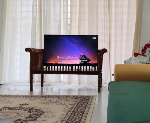 a tv sitting on a bench in a living room at Home Vacays at Kota Puteri in Batu Arang