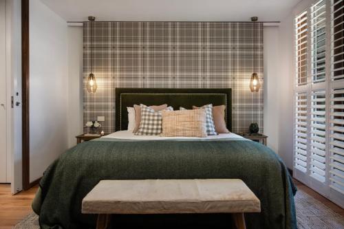 une chambre avec un grand lit avec une couverture verte dans l'établissement Hepburn Spa Pavilions, à Hepburn Springs