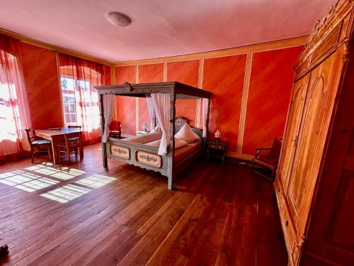 a bedroom with a canopy bed and a wooden floor at Kloster Malgarten in Bramsche