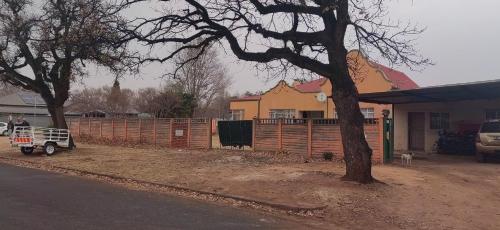 a fence in a yard next to a house at Potch Guest House in Potchefstroom