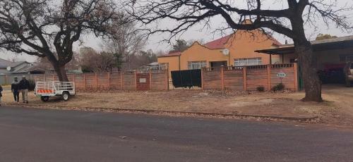 a man walking down a street next to a fence at Potch Guest House in Potchefstroom
