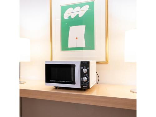 a microwave on a shelf with a picture at Hotel Terrace The Square Hitachi - Vacation STAY 17029v in Hitachi