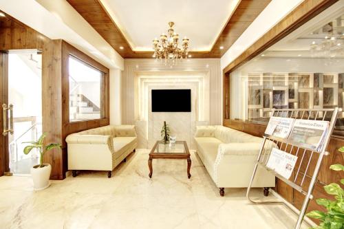 a living room with white furniture and a chandelier at Marks Hotel & Banquet in Noida