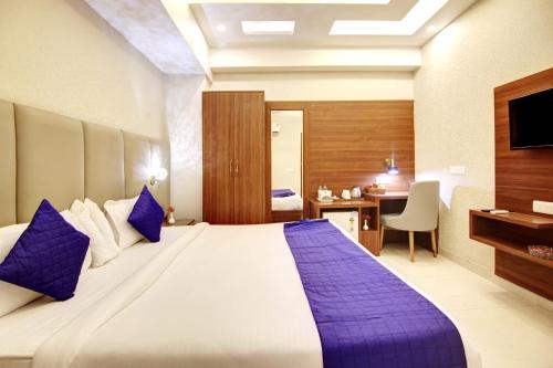 a hotel room with a large bed and a desk at Marks Hotel & Banquet in Noida