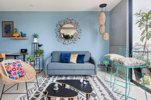 a living room with a blue couch and chairs at Savor City Views over Breakfast at a Bold, Bohemian Escape in Mexico City