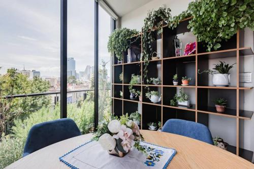 a room with a table and chairs and a shelf with plants at Savor City Views over Breakfast at a Bold, Bohemian Escape in Mexico City