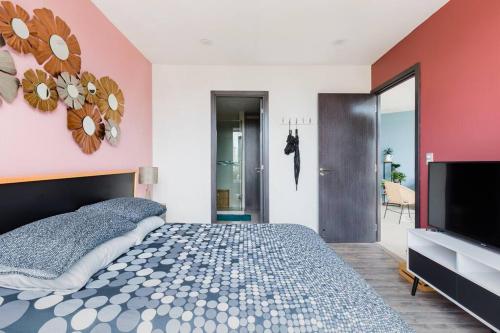 a bedroom with a bed and a flat screen tv at Savor City Views over Breakfast at a Bold, Bohemian Escape in Mexico City