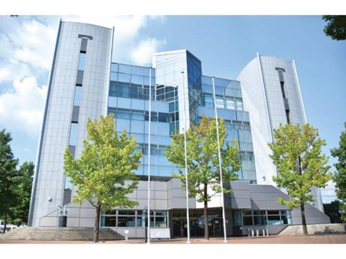 a tall glass building with trees in front of it at Sun Hotel Tosu Saga - Vacation STAY 49476v in Tosu