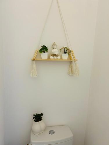 a bathroom with a toilet with a shelf above it at Cosy Nest Deva in Deva