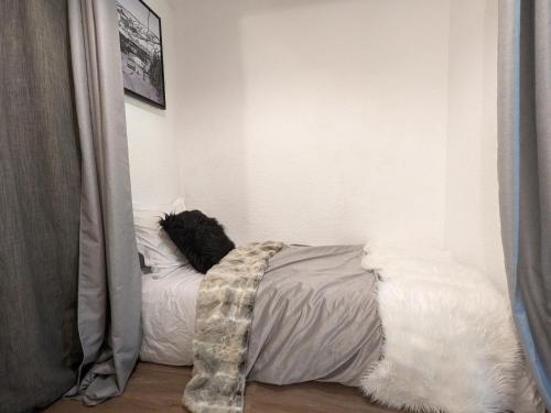 une chambre avec un lit avec des draps blancs dans l'établissement studio terrasse de charme près des pistes, à Bernex