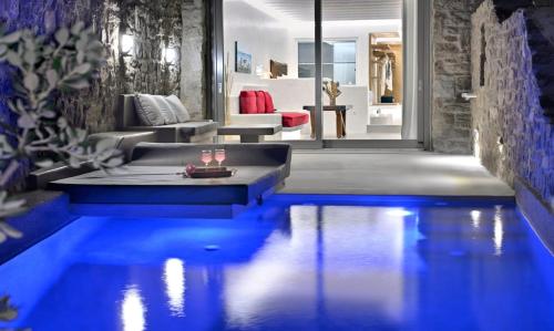 a living room with a swimming pool in the middle of a house at AC Village Christoulis in Mýkonos City