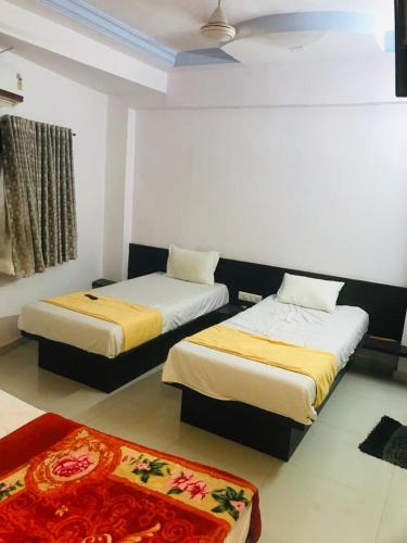 a room with two beds and a rug at hotel royal night in Ahmedabad