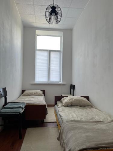 a bedroom with two beds and a window at Dzīvoklis īstermiņā in Liepāja