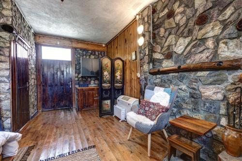 a living room with a stone wall and a chair at Chalet Parea in Metamorfosi