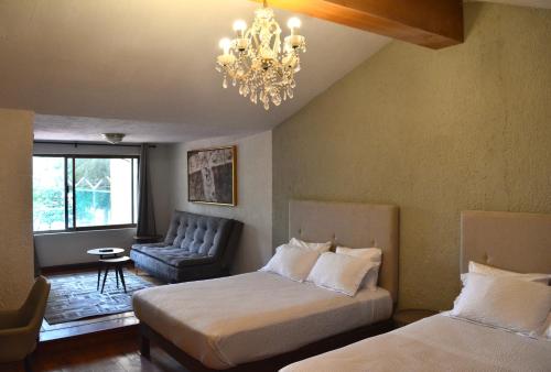 a hotel room with two beds and a chandelier at Casa Palmas in Guadalajara