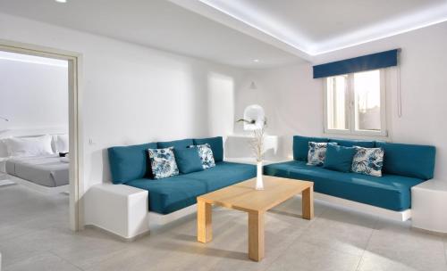 a living room with a blue couch and a table at AC Village Christoulis in Mýkonos City