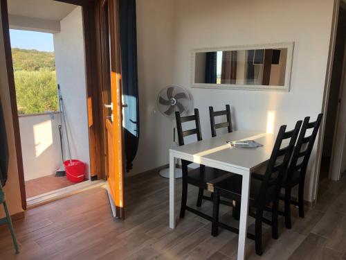 a dining room with a table and chairs and a window at La Maremmana in Talamone