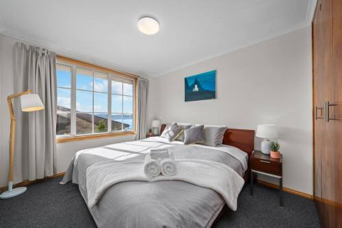 サンディ・ベイにあるLuxury Sandy Bay Living River Views Free Parkingの大きなベッドと大きな窓のある寝室