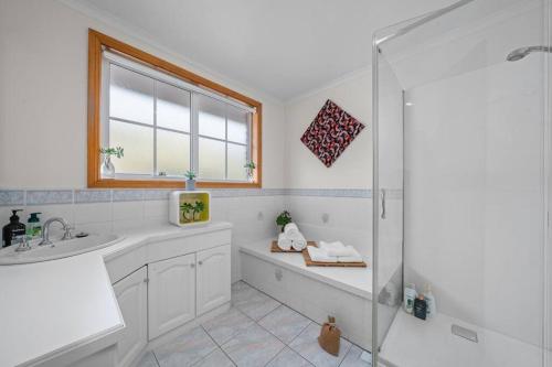 サンディ・ベイにあるLuxury Sandy Bay Living River Views Free Parkingのシャワーと洗面台付きのバスルーム