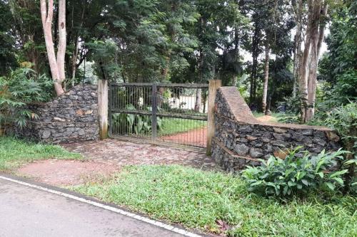 a fence in front of a stone wall at Rustic Villa In Kalutara South in Kalutara North
