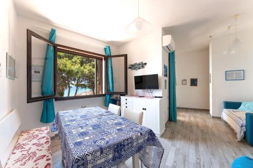 a room with a bed and a table and a window at Casa Turchese, Sea View Beachfront in Santa Margherita di Pula