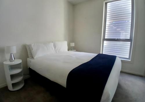a bedroom with a large bed and a window at Docklands Serenity in Melbourne