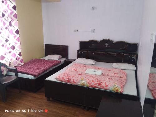 a room with two beds and a chair in it at Hotel The Tragopan in Sarāhan