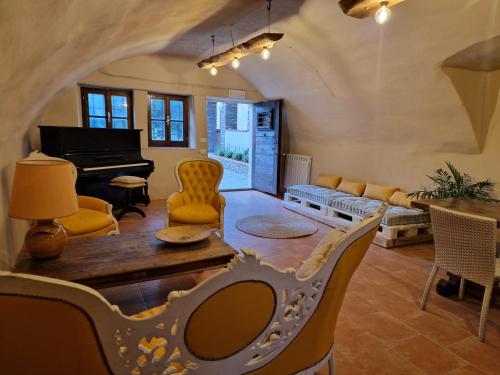 a living room with a table and a piano at La Pietra di Ebenezer in Filetto