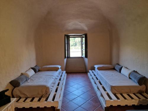 three beds in a room with a window at La Pietra di Ebenezer in Filetto