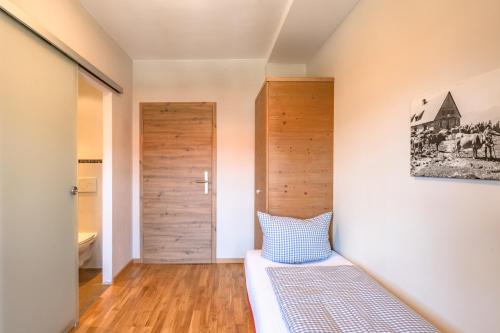 a bedroom with a bed and a wooden door at Hotel Alpensonne in Bad Wiessee