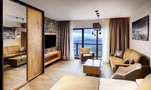 a living room with a couch and a tv at APLEND Monte Móry in Štrbské Pleso