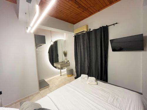 a bedroom with a white bed and a mirror at Island Apartments in Mesolongion