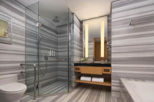 a bathroom with a shower and a toilet and a sink at Ningbo Marriott Hotel in Ningbo