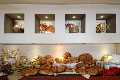 uno scaffale con un mucchio di pane e pasticcini di Blue Bay Resort Hotel ad Agia Pelagia