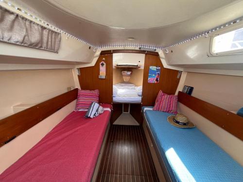 Cette petite chambre comprend deux lits à l'arrière d'un bateau. dans l'établissement Voilier et plage, au Cap d'Agde