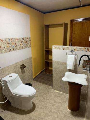 a bathroom with a toilet and a sink at Wilderness Jungle Camp in Malavalli