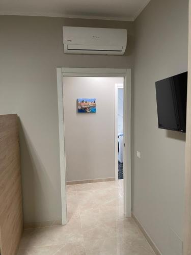 a hallway with a door with a tv and a wall at Therma Luxury house in Termoli