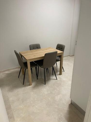 a wooden table and four chairs in a room at Therma Luxury house in Termoli
