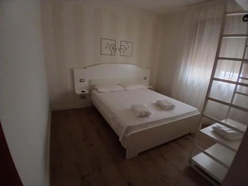Un pequeño dormitorio con una cama blanca en una habitación en The Magic Place, en Quartu SantʼElena
