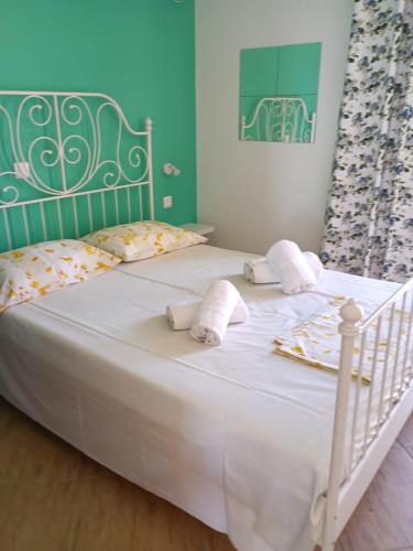 a bedroom with a white bed with towels on it at Dimitris House in Karistos