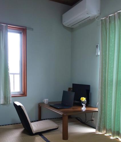 a room with a desk with a laptop on it at Guest House Fuku-chan in Kaiyo
